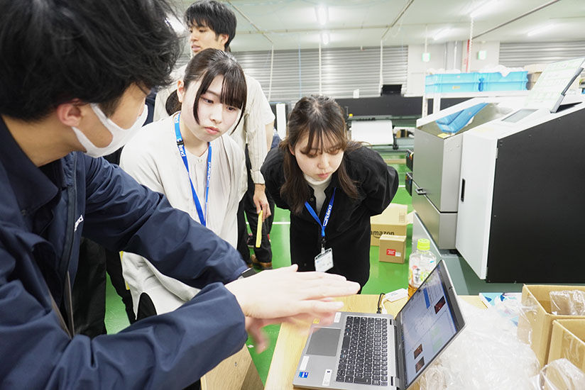専用ソフトウェアの操作方法を教わる新入社員