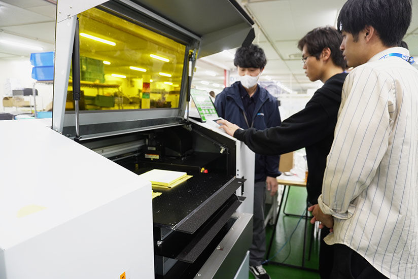 New employees operating the MO-240 UV flatbed printer