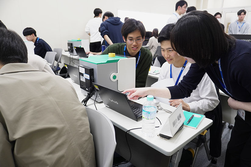 操作するポイントを教わる新入社員