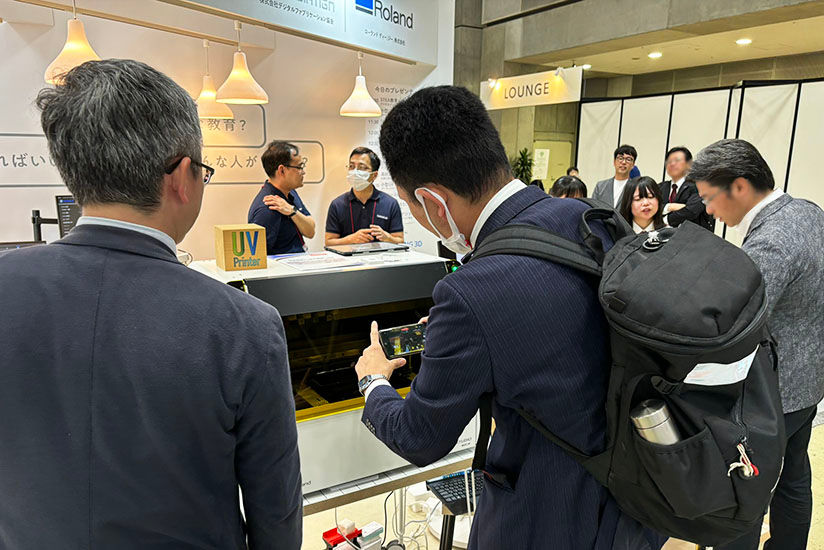 Attendees captivated by UV printer demonstrations