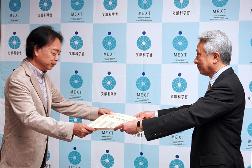 Yoshida receiving the certificate from the Minister