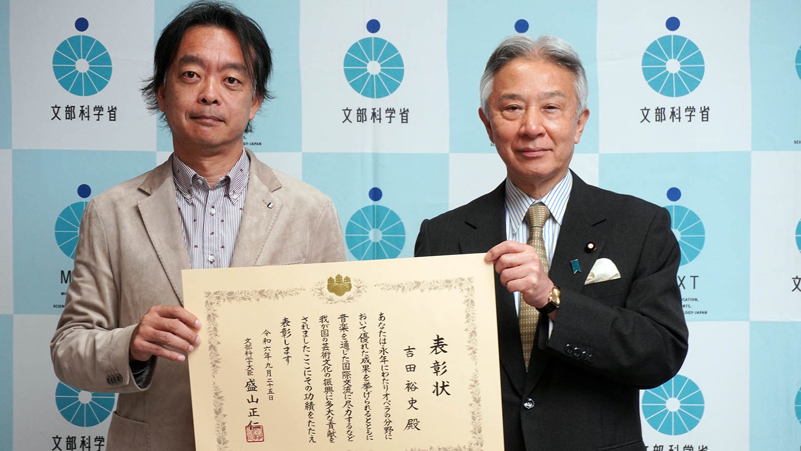 Hirofumi Yoshida and the Minister of Education, Culture, Sports, Science and Technology holding a certificate for a commemorative photo