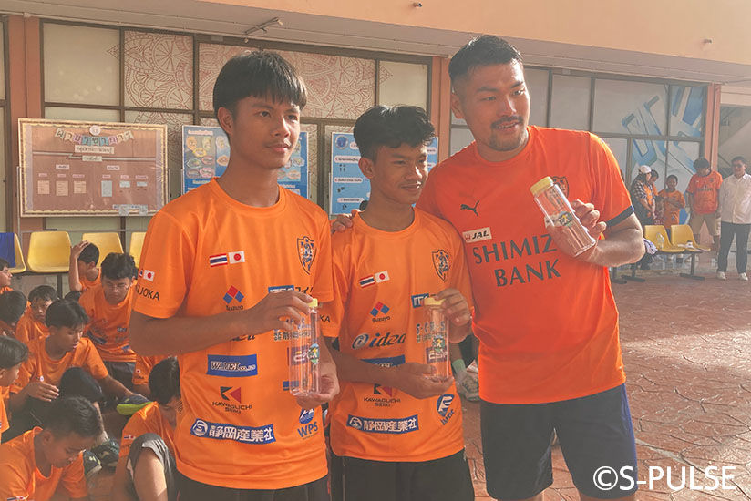 Group photo with Takumi Kato holding bottles