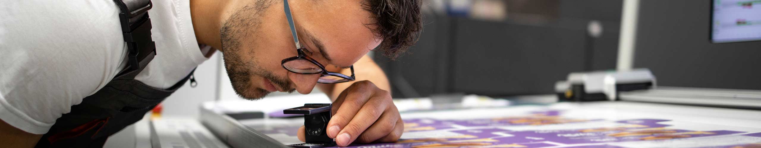 A print professional inspecting print for flaws