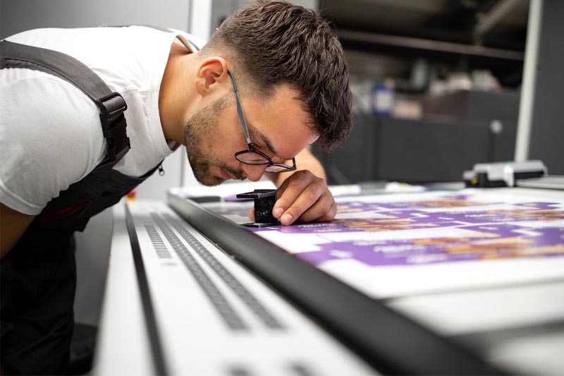 A print professional inspecting print for flaws